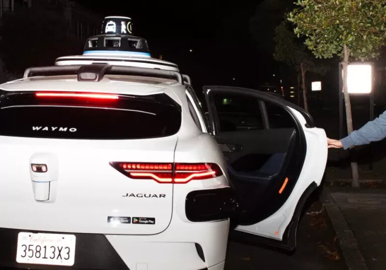 Robotaxis can drive themselves, but still pay humans $20 to close the door